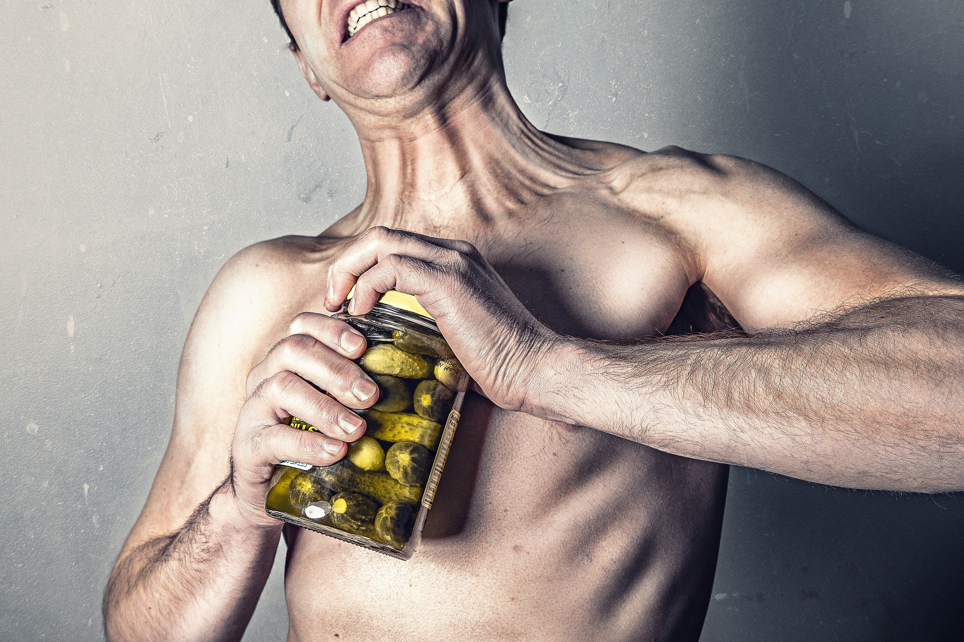 Man struggling to open jar